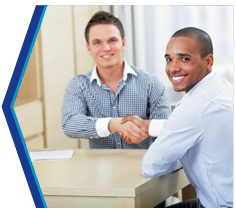 Loan officer and borrowers smiling at the closing table.