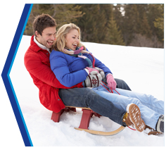 A man and woman sled riding.