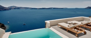 Oceanfront infinity pool and lounge terrace overlooking the sea at sunset