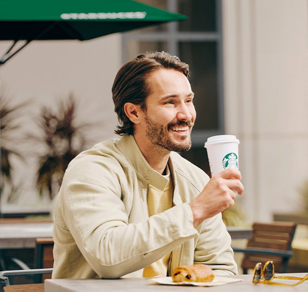 Man drinking Starbucks coffee.