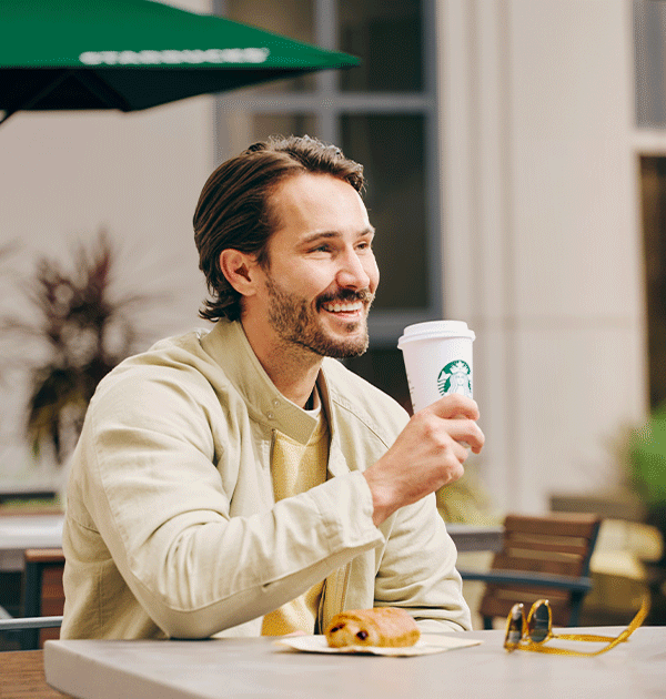 Man drinking Starbucks coffee.