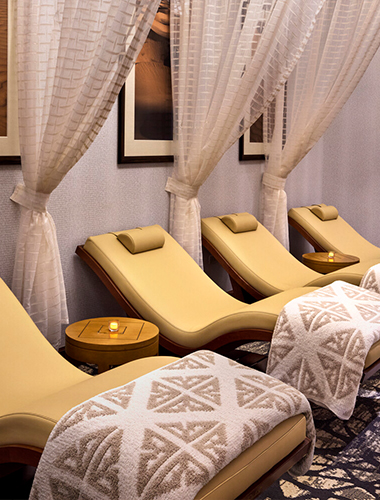 A row of reclining chairs inside a spa.