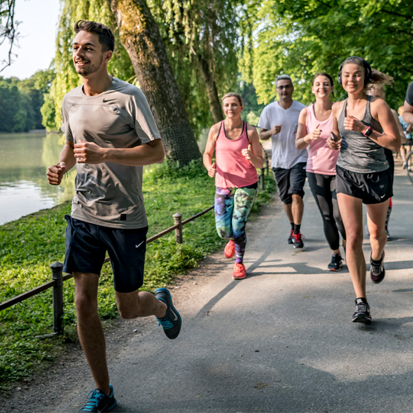 A group of adults jogging through a park