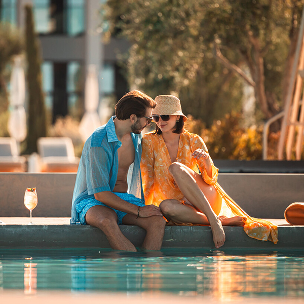 A romantic couple sitting poolside