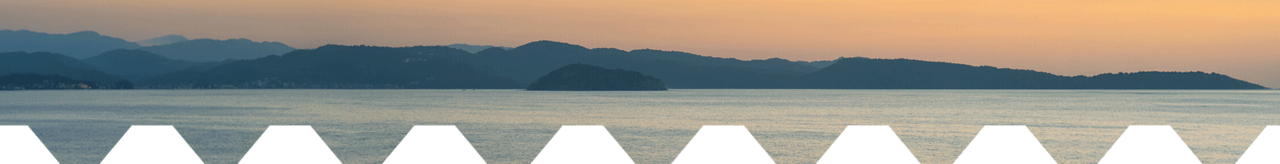 Panoramic sunset over a calm lake with layered mountain silhouettes, warm orange sky, and a bold white zigzag geometric foreground border.