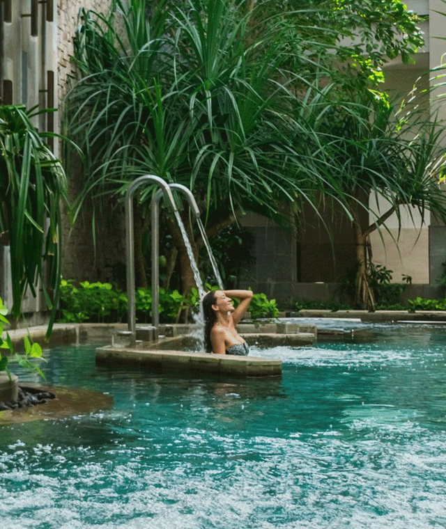 Animated GIF of a woman in a spa pool and a cabana overlooking the sea.